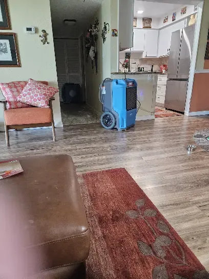 Dehumidifier drying a Venice, FL living room after a leak