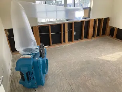 Dehumidifier with a lay-flat duct drying a flood-cut room in Venice, FL